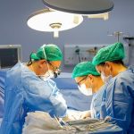 Equipe médica realiza cirurgia em centro cirúrgico, com foco em transplante de fígado.