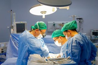Equipe médica realiza cirurgia em centro cirúrgico, com foco em transplante de fígado.