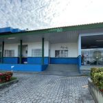 Fachada da 26º DIP (Distrito Integrado de Polícia) em Manaus, com céu nublado.