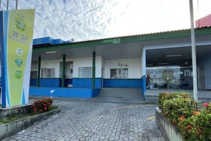 Fachada da 26º DIP (Distrito Integrado de Polícia) em Manaus, com céu nublado.