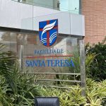 Fachada da Faculdade Santa Teresa com logotipo e vegetação.