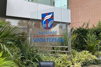 Fachada da Faculdade Santa Teresa com logotipo e vegetação.