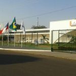 Fachada da Faculdade Senac em Parintins com bandeiras hasteadas.