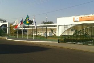 Fachada da Faculdade Senac em Parintins com bandeiras hasteadas.