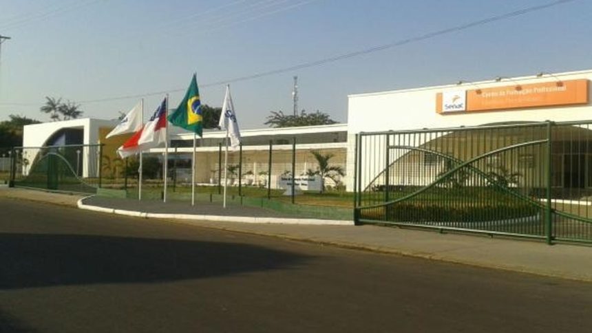 Fachada da Faculdade Senac em Parintins com bandeiras hasteadas.