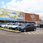 Fachada da Feira de Livros Sesc no Centro de Convenções Vasco Vasques, com carros estacionados.