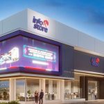 Fachada da Info Store, com letreiro e promoções em destaque.