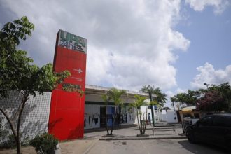 Fachada da UPA 24h, Unidade de Pronto Atendimento, com céu nublado ao fundo.