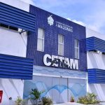 Fachada do CETAM em Manaus, com design moderno e lixeiras coloridas.