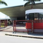 Fachada do Senac em Tefé, com portão vermelho e árvores.