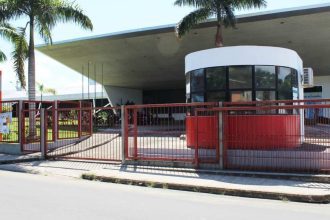 Fachada do Senac em Tefé, com portão vermelho e árvores.