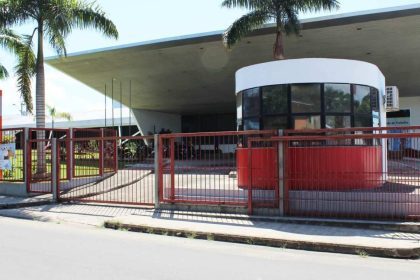 Fachada do Senac em Tefé, com portão vermelho e árvores.