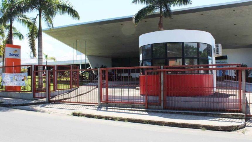 Fachada do Senac em Tefé, com portão vermelho e árvores.