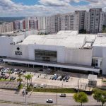 Fachada do Shopping Ponta Negra em Manaus, com prédios ao fundo e estacionamento.