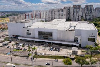Fachada do Shopping Ponta Negra em Manaus, com prédios ao fundo e estacionamento.