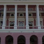 Fachada do Teatro Amazonas, com colunas brancas e detalhes em rosa.