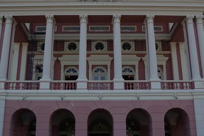 Fachada do Teatro Amazonas, com colunas brancas e detalhes em rosa.