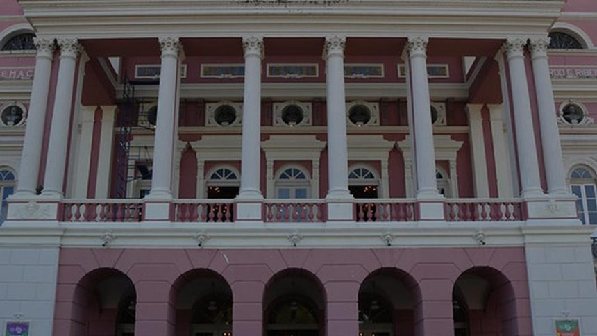 Fachada do Teatro Amazonas, com colunas brancas e detalhes em rosa.