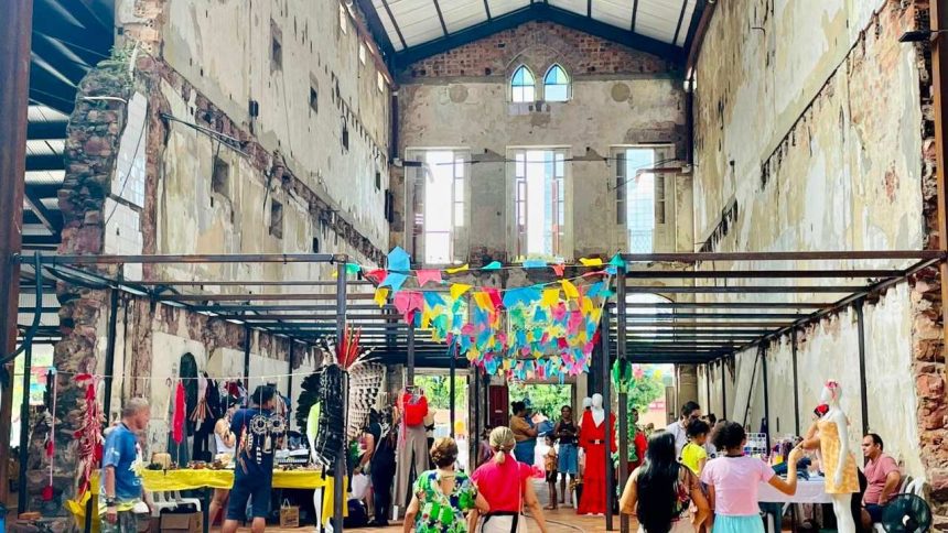 Feira criativa Caipora com pessoas e expositores em espaço com arquitetura antiga.