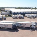 Frota de caminhões 'Combitrans' estacionados em pátio logístico, com foco em transporte e sustentabilidade na Amazônia.