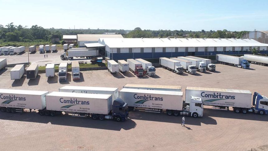 Frota de caminhões 'Combitrans' estacionados em pátio logístico, com foco em transporte e sustentabilidade na Amazônia.