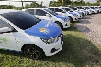 Frota de veículos do programa Melhor em Casa estacionados em fila.