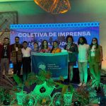 Grupo de jovens líderes da Amazônia Legal com bandeira em evento COP 30.