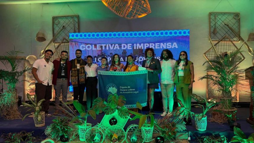 Grupo de jovens líderes da Amazônia Legal com bandeira em evento COP 30.