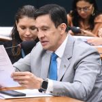 Homem de terno lendo documentos durante reunião