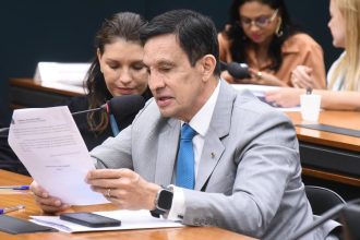 Homem de terno lendo documentos durante reunião