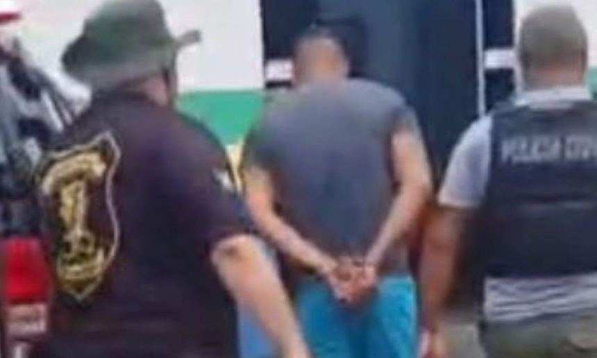 Homem preso sob custódia policial. Detido com as mãos algemadas.