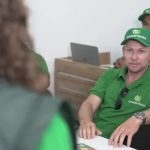 Homens em curso de Técnico em Segurança do Trabalho, usando bonés e camisas verdes.