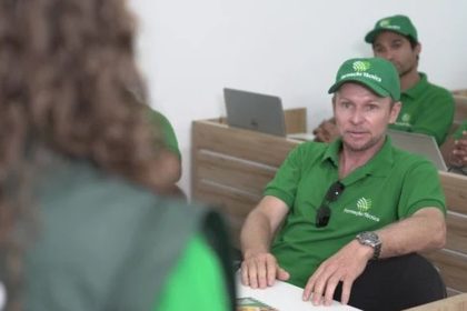 Homens em curso de Técnico em Segurança do Trabalho, usando bonés e camisas verdes.