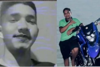 Imagem de jovens, um em preto e branco e outro em pé ao lado de uma moto azul.