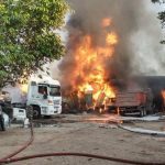 Incêndio em galpões e veículos no bairro Tarumã, com chamas e fumaça densa.