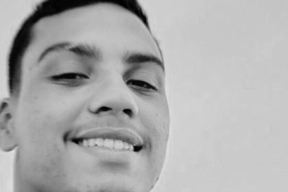 Jovem sorrindo em preto e branco.