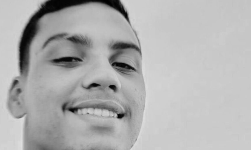 Jovem sorrindo em preto e branco.