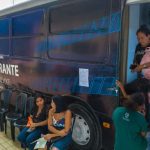 Justiça Itinerante em Manaus, ônibus com pessoas entrando e esperando.