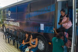 Justiça Itinerante em Manaus, ônibus com pessoas entrando e esperando.