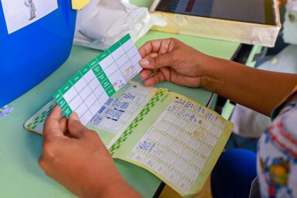 Mãos seguram caderneta de vacinação em consulta médica. Registro de vacinas e saúde.