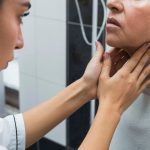 Médica examinando a garganta de uma paciente