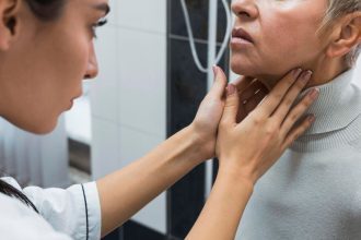 Médica examinando a garganta de uma paciente