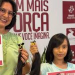 Mulher e menina com certificados e mechas de cabelo doadas para mulheres com câncer.