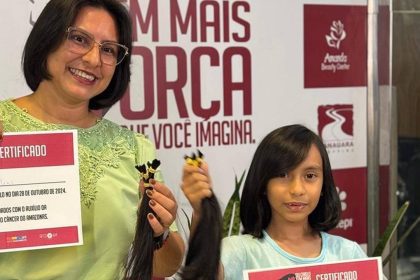 Mulher e menina com certificados e mechas de cabelo doadas para mulheres com câncer.