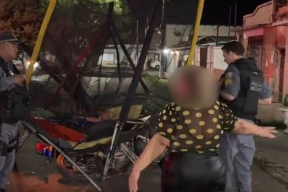 Mulher e policiais em cena de acidente com motocicleta.