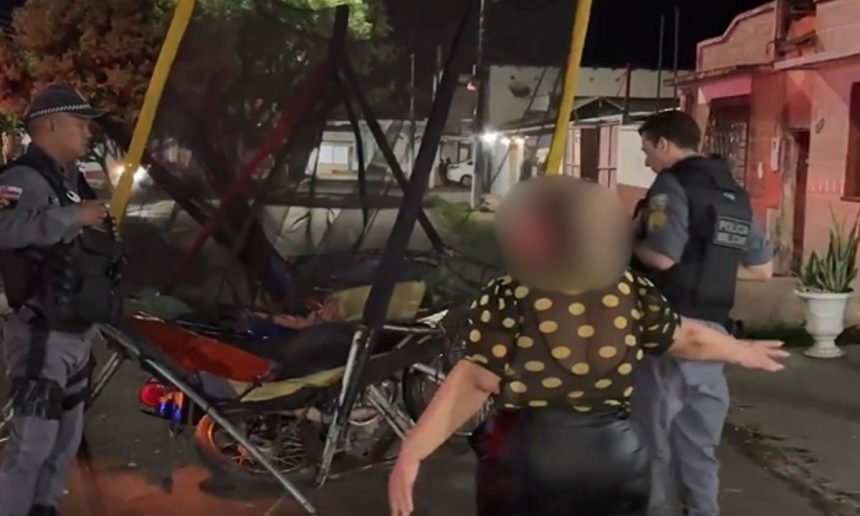 Mulher e policiais em cena de acidente com motocicleta.