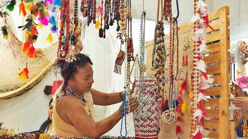 Mulher em feira de artesanato em Manaus, com colares e acessórios coloridos