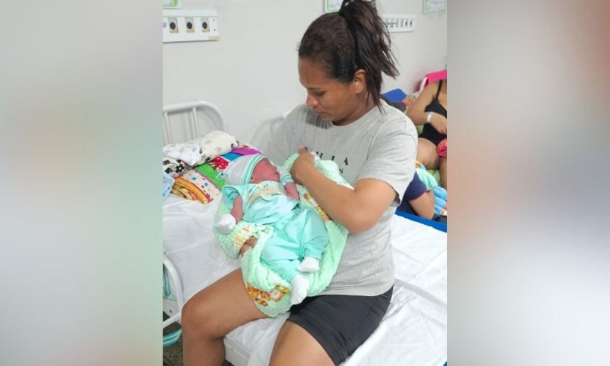 Mulher segura recém-nascido em hospital. Cena de parto no estacionamento do hospital.