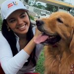 Mulher sorrindo com cachorro golden retriever em evento Pet Run