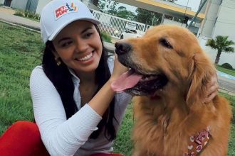 Mulher sorrindo com cachorro golden retriever em evento Pet Run